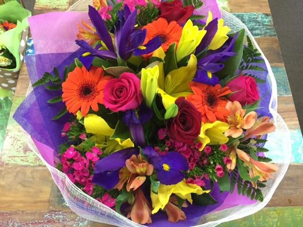 A statement arrangement of colourful flowers in a handy cardboard vase called a vox. These flowers can be delivered and readily enjoyed. A beautfiul cinimay wrap to compliment the colour arrangement, tied with a chiffon ribbon. Butterfly not included unless requested.