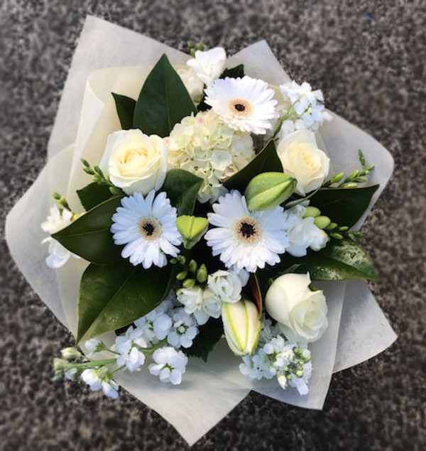 A bouquet of flowers in classic white, hand tied and presented in our signature wrap