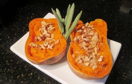A Butternut squash halved and garnished with walnuts