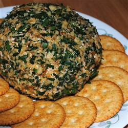 Cheese ball surrounded by round crackers on a plate