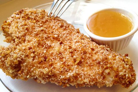 Pecan Baked Chicken on a plate with a dipping sauce and fork