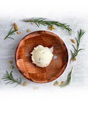 A scoop of rosemary honey walnut ice cream on a checkered bamboo serving bowl