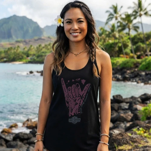 Front view of a smiling woman on a rocky Hawaiian beach wearing the black Harley-Davidson Women's Shaka G Tank Top
