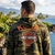 Back view of man wearing Harley-Davidson Men's Kona HD Original Zip Camo Hoodie near ocean coastline