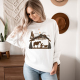 Praying Manger Sublimation Transfer, woman wearing a white sweatshirt with Christmas nativity scene print featuring a stable, donkey, and shepherd, indoors environment.