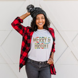 Merry & Bright Leopard Sublimation Transfer, cheerful woman wearing a white t-shirt with the design, red and black checkered shirt, and the sublimation transfer on her shirt.