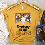 Something In The Orange Leopard DTF Heat Transfer, a yellow T-shirt with a leopard print background, a skull of a longhorn steer, and the text 'Something In The Orange' in bold, stylized font.