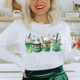 Lucky Lattes DTF Heat Transfer, image of a woman wearing a white sweatshirt with illustrations of four different green-colored latte drinks with shamrocks, representing St. Patrick's Day or Irish theme.