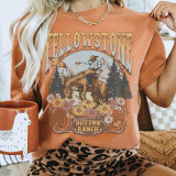 Retro Yellowstone Screen Print Heat Transfer, vintage-style graphic design of a woman riding a horse surrounded by mountains, trees, and flowers on a t-shirt.