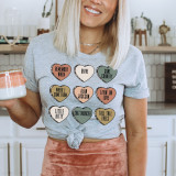 Alan Hearts DTF Heat Transfer, colorful heart-shaped design on a woman's gray t-shirt featuring various phrases and names.
