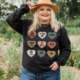 Koe Candy Hearts DTF Heat Transfer, colorful heart-shaped design with humorous and personalized text on a woman's black sweatshirt.