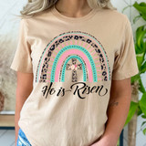 He Is Risen Rainbow DTF Heat Transfer, colorful rainbow design with leopard print and cross, on a beige t-shirt.