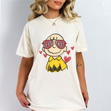 Good Grief DTF Heat Transfer, graphic of Charlie Brown character wearing sunglasses with 'Good Grief' text, on a white T-shirt with hearts.