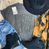 Keep Your Squats Low PUFF Screen Print Heat Transfer, a gray T-shirt with the motivational quote in puff black lettering, surrounded by accessories including a black hat, tie-dye shirt, denim jeans, black boots, and black gloves.