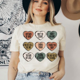Shania Candy Hearts DTF Heat Transfer, colorful heart-shaped designs with various quotes on a woman's t-shirt.
