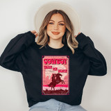 Cowboy Take Me Home DTF Heat Transfer, a woman wearing a black sweatshirt with pink and red cowboy-themed graphics and text, featuring a silhouette of a cowboy on a horse.