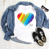 Brush Stroke Rainbow Heart More Love Less Hate Pride Sublimation Transfer, colorful rainbow heart design on a white t-shirt with denim jacket and black sneakers.