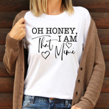 Oh Honey, I Am That Mimi DTF Heat Transfer, woman wearing a white T-shirt with the text 'Oh Honey, I Am That Mimi' and heart illustrations, brown cardigan, denim jeans, wooden background.