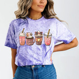 Boss Babe Fuel Lattes DTF Heat Transfer, colorful illustrated latte cups on a purple tie-dye t-shirt worn by a woman.