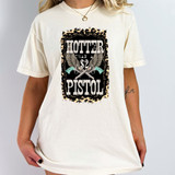 Hotter Than A $2 Pistol DTF Heat Transfer, featuring a bold graphic design with guns and wings on a white T-shirt.