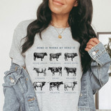 Home Is Where My Herd Is DTF Heat Transfer, woman wearing a graphic t-shirt with illustrations of different cattle breeds.