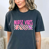 Nurse Vibes DTF Heat Transfer, pink and purple nurse-themed graphics with medical supplies on a dark-colored t-shirt.