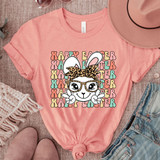 Happy Easter Boho Bunny DTF Heat Transfer, pink t-shirt with a cute bunny wearing glasses and a leopard print bowtie, surrounded by colorful 'Happy Easter' text.