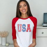 USA Pattern DTF Heat Transfer, close-up of a woman wearing a white and red baseball-style shirt with 'USA' printed in patriotic patterned letters.