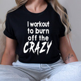 Workout To Burn Off The Crazy WHITE DTF Heat Transfer, a woman wearing a black T-shirt with white bold text and casual gray sweatpants.