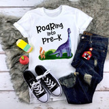 Roaring Into Pre-K Dinosaur Back To School Sublimation Transfer, white T-shirt with colorful dinosaur and playful text for preschoolers.