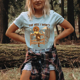 The Hell I Won't DTF Heat Transfer, graphic design of a woman running through desert landscape with cacti and mountains in the background, in earthy tones on a light blue t-shirt.