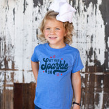Get Your Sparkle On DTF Heat Transfer, a girl wearing a blue t-shirt with the phrase 'Get Your Sparkle On' in bold letters and star designs in the print.