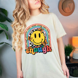 You're More Than Enough DTF Heat Transfer, colorful graphic design featuring a smiling yellow face, rainbow, butterflies, and inspirational words on a woman's t-shirt.