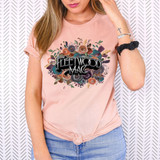 FW MAC DTF Heat Transfer, a colorful floral design with Fleetwood Mac logo printed on a woman's pink T-shirt.