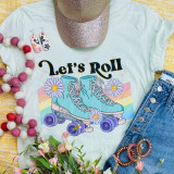 Let's Roll Screen Print Heat Transfer, vibrant graphic print of roller skates on a T-shirt with floral and rainbow design, surrounded by accessories.
