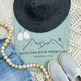 Faith Can Move Mountains Screen Print Heat Transfer, inspirational clothing design with mountain illustration, quote from Matthew 17:20, on light blue fabric with accessories.