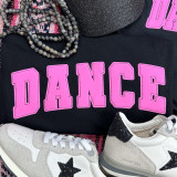 Dance Pink Adult Screen Print Heat Transfer, black t-shirt with pink 'DANCE' print, white sneakers with black star detail, black glittery hat, and beaded necklace.