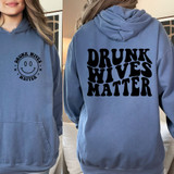 Drunk Wives Matter Happy Face DTF Heat Transfer, blue hoodie with black text on the back and a smiley face logo on the front.