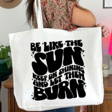Be Like The Sun BLACK DTF Heat Transfer, a black and white tote bag with a motivational quote in bold, playful font.