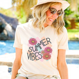 Summer Vibes Boho DTF Heat Transfer, a woman wearing a white T-shirt with colorful flower and text design, enjoying a sunny summer day outdoors.