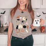 Halloween Doodles DTF Heat Transfer, a woman wearing a T-shirt adorned with various Halloween-themed illustrations including a skull, spider, witch hat, black cat, bat, cauldron, and other spooky symbols.