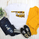 Oklahoma Leopard and Sunflower with Home Sublimation Transfer T-shirt, with sunflower and leopard print design, paired with distressed jeans, black Vans sneakers, and yellow clothing on a light wood background.