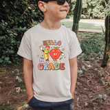 Hello 1st Grade Retro DTF Heat Transfer, a colorful heat transfer design featuring a cheerful pencil and apple character with the text "Hello 1st Grade" on a child's t-shirt.