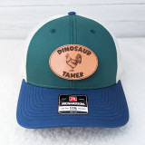 Dinosaur Tamer Leather Hat Patch, embroidered patch with a rooster illustration and the text 'Dinosaur Tamer' on a styled cap.