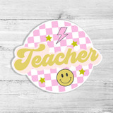Checkered Teacher Die Cut Sticker, pink and white checkered background with yellow 'Teacher' text, smiley face, stars, and lightning bolt design.