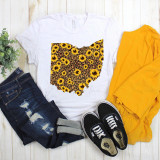 Ohio Leopard Sunflower Sublimation Transfer, white T-shirt with sunflower and leopard print Ohio shape design, paired with distressed jeans, black Vans sneakers, yellow hoodie, and a small green plant on a white wooden floor.