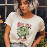Grow Wild Be Happy DTF Heat Transfer, woman wearing a T-shirt with a potted plant and cheerful smile design.