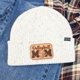 Volleyball Mom Leather Hat Patch, a rectangular leather patch with the words 'Volleyball MOM' and a volleyball graphic, sewn onto a cream-colored knitted hat.