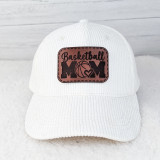 Basketball Mom Leather Hat Patch, white corduroy baseball cap with a brown leather patch embroidered with the word 'Basketball Mom', a basketball, and a heart symbol.