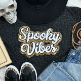 Spooky Vibes Sequins and Chenille Patch, decorative patch with the phrase 'Spooky Vibes' in white sequins outlined with gold and black beads, on a black fabric background with fashion accessories.
